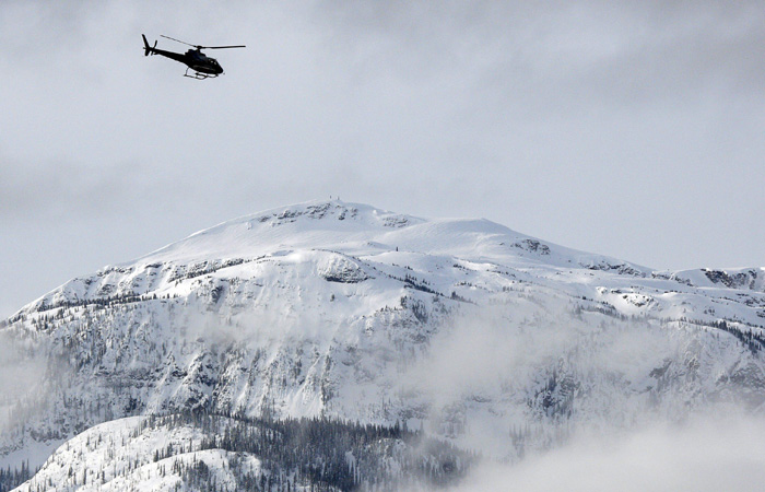 A search and rescue helicopter heads toward the area where a large avalanche struck near Revelstoke, British Columbia, Sunday, March 14, 2010. The avalanche struck an informal snowmobile rally Saturday in Canada's Rocky Mountains, killing at least three people and leaving an unknown number missing. Rescuers resumed scouring remote Boulder Mountain at daybreak Sunday after halting the search overnight. Police also conducted a door-to-door search of hotel rooms early Sunday to piece together how many people were missing from the Big Iron Shoot Out rally. (AP Photo/The Canadian Press, Jeff McIntosh)