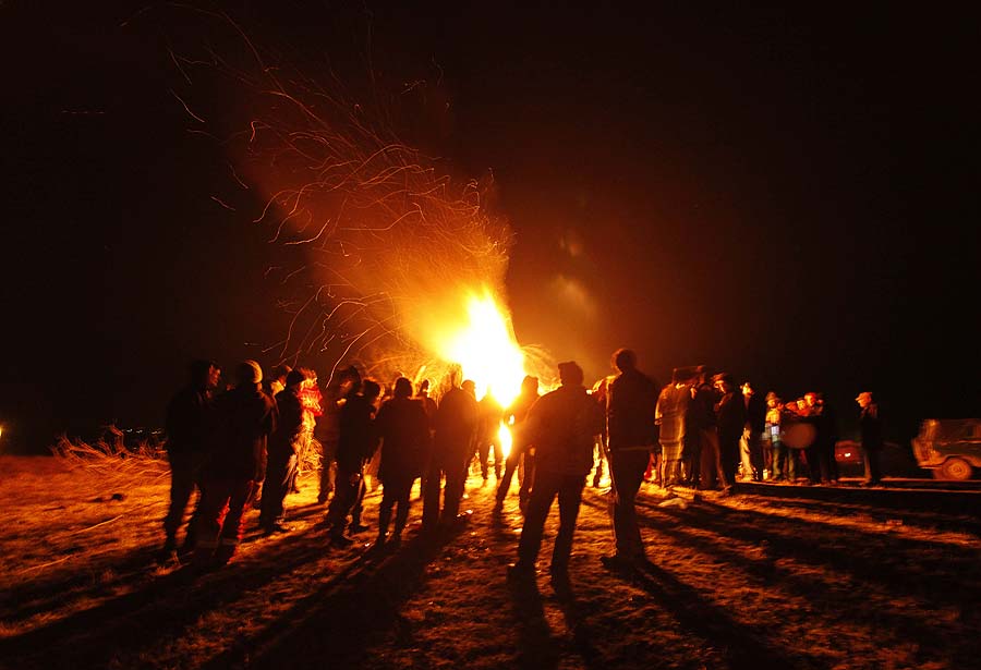 A long exposure photo shows silhouettes of people gathered near a bonfire during rituals in celebration of Mesni Zagovezni (Shrovetide) in the village of Lozen near the capital Sofia, Sunday, Feb. 27, 2011. People in this region believe they can chase away evil spirits with fire rituals on Mesni Zagovezni  (AP Photo/Valentina Petrova)