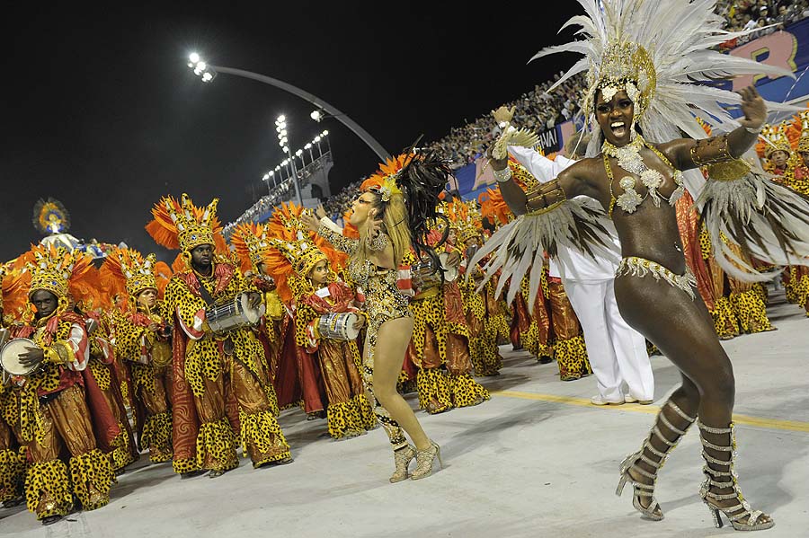 Revellers of Academicos do Tucuruvi samba school perform ahead of drummers during the opening night of parades at the Sambadrome, as part of Carnival celebrations in Sao Paulo early on March 5, 2011. Brazil's Carnival kicked off on the eve with millions of people taking to the streets of the northeastern city of Salvador de Bahia to dance and party, effectively putting the nation on a week-long hiatus. AFP PHOTO/Mauricio LIMA