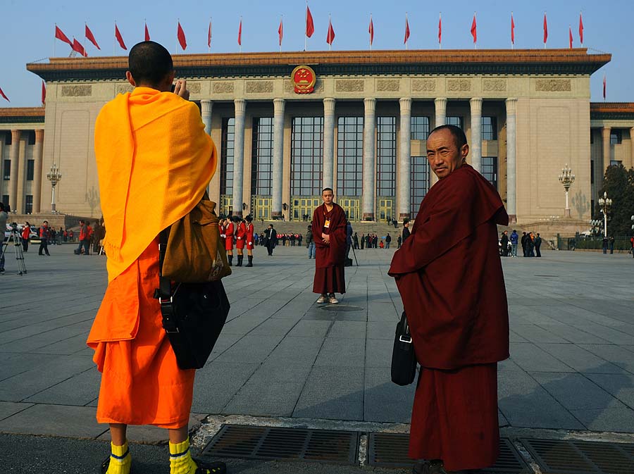 Buddhist monks wearing official staff badges take photos of each other during the the opening session of the National People's Congress (NPC) at the Great Hall of the People in Beijing on March 5, 2011.  In a 
