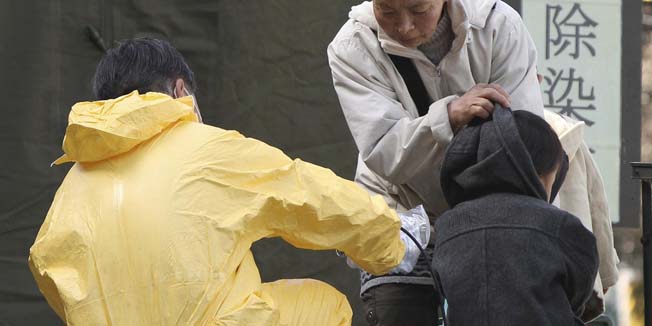 A boy has his radiation level checked in the compound of Fukushima Gender Equality Centre in Nihonmatsu, Fukushima Prefecture, northeastern Japan, Sunday morning, March 13, 2011 after being evacuated from a town located near the troubled Fukushima Dai-ichi nuclear power plant. People live around the nuclear complex might have been exposed to radiation after an explosion of Unit 1 reactor of the complex blew off the top part of its walls on Saturday, one day after a strong earthquake and tsunami hit northeastern Japan. (AP Photo/The Yomiuri Shimbun, Daisuke Tomita)  JAPAN OUT, CREDIT MANDATORY