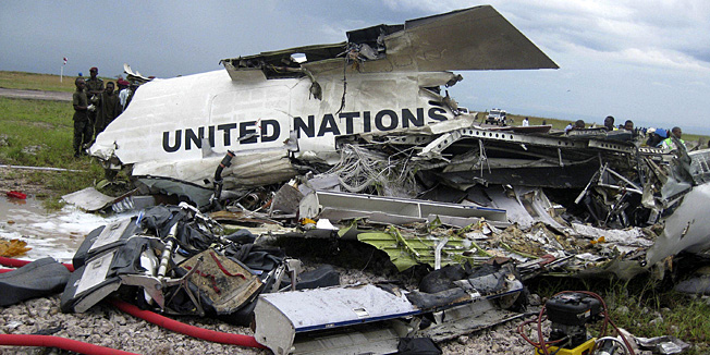 Onlookers stand around the wreckage of a U.N. plane that crashed as it was landing in Kinshasa, Congo, on Monday, April 4, 2011. Only one person survived among the 33 U.N. personnel and crew members aboard the plane, U.N. officials said. (AP Photo/John Bompengo)