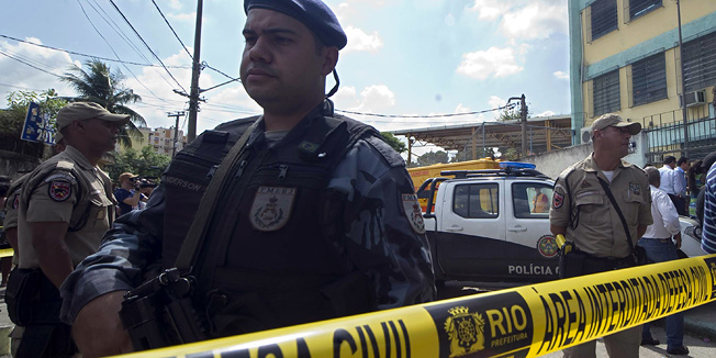 Police officers are seen in fron of the Tasso de Oliveira school where 12 people were shot dead and 22 wounded by a man  believed to be a former student of the school on March 07, 2011, Rio de Janeiro, Brazil.    AFP   PHOTO  ANTONIO SCORZA