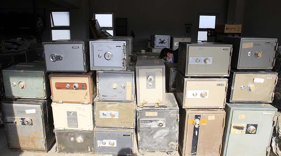 In this photo taken on April 7, 2011, a police office cleans cashboxes after they collected those from damaged houses at a police station in tsunami-hit Ofunato city, Iwate Prefecture, Japan. Safes were washing up along the tsunami-battered coast, and police were trying to find their owners, a unique problem in the country where many people, especially the elderly, still stash their cash at home. (AP Photo/Lee Jin-man)