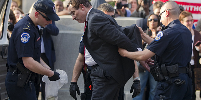 Mayor Vincent Gray is searched by Capitol Hill police after being arrested on Monday, April 11, 2011, in Washington.  Gray and several members of the D.C. city council joined protesters blocking the street in front of a Senate Office building to protest restrictions placed upon the district as part of the federal budget deal.  (AP Photo/Evan Vucci)
