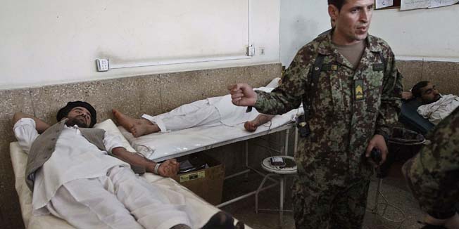 Wounded Afghans lie on beds at the main hospital in Jalalabad on April 16, 2011, after they were injured in an attack. A Taliban suicide bomber wearing an army uniform killed five foreign troops and four Afghan soldiers in a brazen attack at the Afghan army's eastern headquarters. It was the deadliest single incident this year against foreign forces in war-torn Afghanistan and comes amid a wave of suicide attacks on security targets, three months before foreign forces start a limited pullback. AFP PHOTO/STR