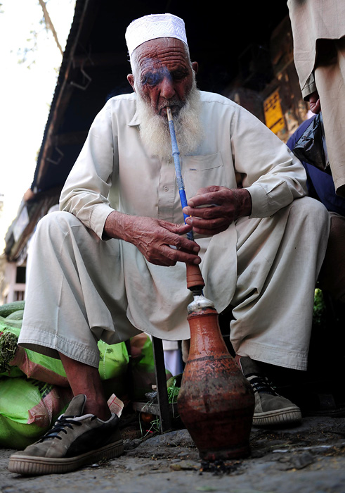 Pakistani Gul Rehman 92, smokes a traditional Hookah pipe on the roadside in Abbottabad on May 7, 2011, where bin Laden was found and killed by US commandos in a shock operation on May 2. Osama bin Laden's wife said the Al Qaeda kingpin had lived with family in a compound in Abbottabad for five years before he was shot dead by US forces, Pakistani security officials said.   AFP PHOTO/Asif HASSAN
