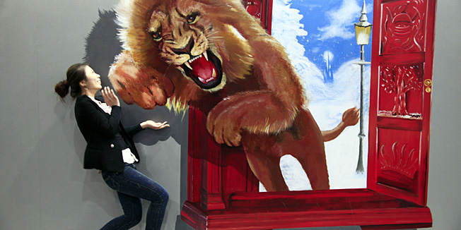 A Chinese woman poses with a four-dimensional (4D) painting on display at a contemporary art exhibition in Jilin, northeast China's Jilin's province on May 14, 2011. China overtook Britain as the world's second biggest market for art and antiques in 2010, said a report from the European Fine Art Fair (Tefaf) opening in the Netherlands. CHINA OUT  AFP PHOTO