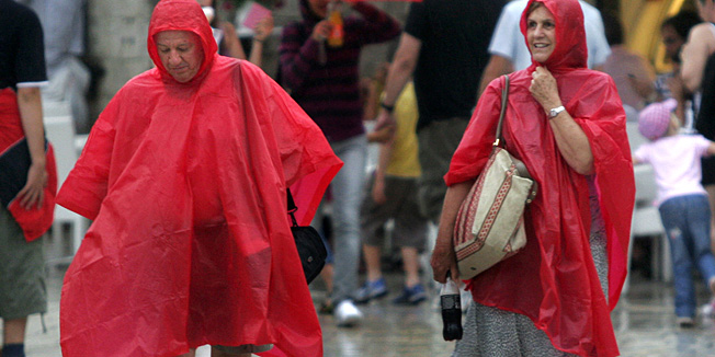 Dubrovnik , 050909.Kisa koja je nakon dugo vremena pala u Dubrovniku nije sprjecila brojne turiste , pogotovo one s usidrenih kruzera da navucu kisne ogrtace (kabanice) i obidju turisticke ljepote Dubrovnika.Foto : Branimir Kvartuc / CROPIX