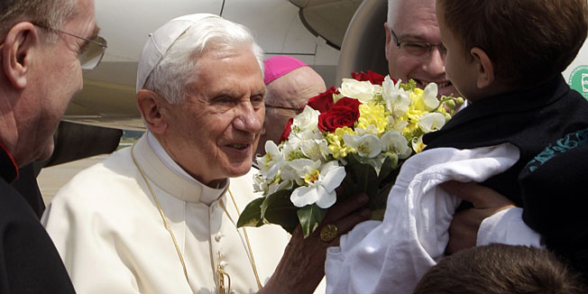 Pope Benedict XVI, standing beside Croatian president Ivo Josipovic, right, behind child, greets youth wearing traditional costumes upon his arrival in Zagreb, Croatia, Saturday, June 4, 2011. Pope Benedict XVI is visiting the Croatian capital from June 4 to 5 for the first time. (AP Photo/Pier Paolo Cito)
