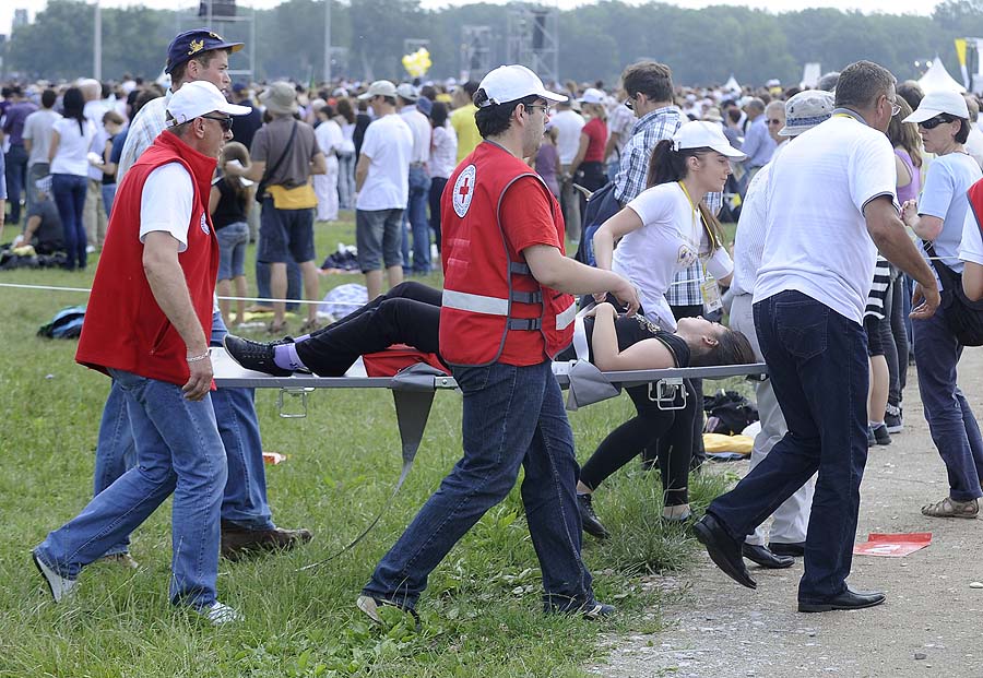Zagreb, 050611. Hipodrom.Posjet Pape Benedikta XVI. Hrvatskoj - Zagreb, 04. i 05. lipnja. Svecano euharistijsko slavlje povodom Nacionalnog dana obitelji.Na slici: vjernici kojoj je pozlilo na euharistijskom slavlju odvode aktivisti Crvenog kriza do prve pomoci.Foto: Marko Miscevic / CROPIX