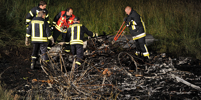 Firemen work at the accident site of a crashed zeppelin on late June 12, 2011 in Reichelsheim, western Germany. The pilot of the zeppelin was killed and three passengers had to leap to safety when the aircraft caught fire and crashed, a police spokesman said. The zeppelin had been making a promotional flight to mark a local festival.     AFP PHOTO    ARNE DEDERT    GERMANY OUT