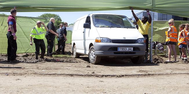 A private ambulance is driven out of the VIP backstage area of Hospitality at Glastonbury Music Festival, after a man was found dead in a portable toilet, Sunday, June 26, 2011. A close friend of British Prime Minister David Cameron has been found dead in a portable toilet at the Glastonbury music festival. Cameron said he was devastated to hear of the death of Christopher Shale, who chaired his West Oxfordshire constituency's Conservative Association. Cameron said Shale was a 