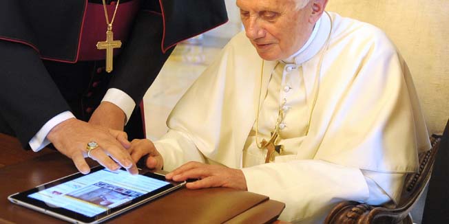 Pope Benedict XVI uses a tablet in his private office at the Vatican on June 28, 2011 to launch a new website making it easier to access all Vatican news online.  Pope Benedict XVI wrote a message on Twitter on Tuesday praising Jesus and announcing the launch of a new Vatican website in the first 