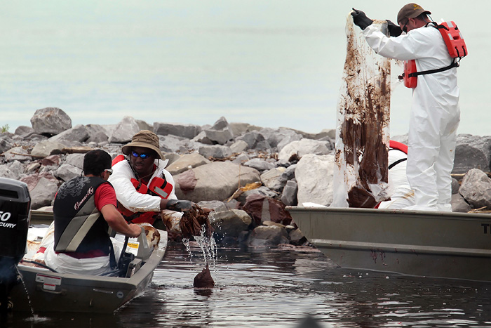 GULFPORT, MS - JULY 1: Oil cleanup workers try to remove thick oil that washed ashore from the Deepwater Horizon oil spill in the Gulf of Mexico on July 1, 2010 in Gulfport, Mississippi. Millions of gallons of oil have spilled into the Gulf since the April 20 explosion on the drilling platform.   Joe Raedle/Getty Images/AFP== FOR NEWSPAPERS, INTERNET, TELCOS & TELEVISION USE ONLY ==