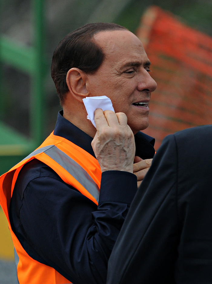 Italian Prime Minister Silvio Berlusconi cleans his face during the inauguration of the construction project of the third set of locks that form part of the extension of the Panama Canal in Gatun, some 100 km north of Panama City, on June 30, 2010.AFP PHOTO/ Elmer MARTINEZ