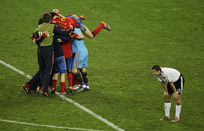 Germany's Miroslav Klose, right, is seen as Spain players, left, celebrate following the World Cup semifinal soccer match between  Germany and Spain at the stadium in Durban, South Africa, Wednesday, July 7, 2010. Spain defeated Germany 1-0. (AP Photo/Hassan Ammar)