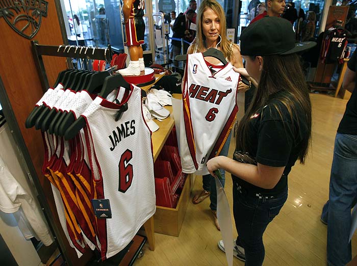 A guest purchases a LeBron James jersey at a store as NBA basketball team Miami Heat hosts 'HEAT Summer of 2010 Welcome Event' at the American Airlines Arena in Miami, Florida July 9, 2010. James, Dwyane Wade and Chris Bosh, all free agents, have committed to play for the Miami club.    REUTERS/Hans Deryk (UNITED STATES - Tags: SPORT BASKETBALL)