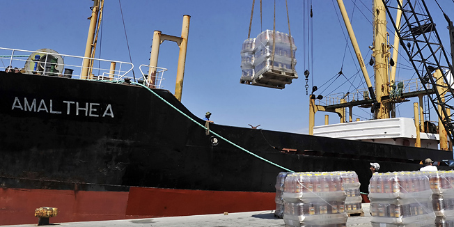Crates of cooking oil are loaded on to the cargo ship 'Amalthea' at the Lavrio port, about 60 kilometers (37 miles) southeast of Athens on July 9, 2010. A charity headed by the second son of Libyan leader Moamar Kadhafi is sending an aid boat from Greece to Gaza to break the Israeli 