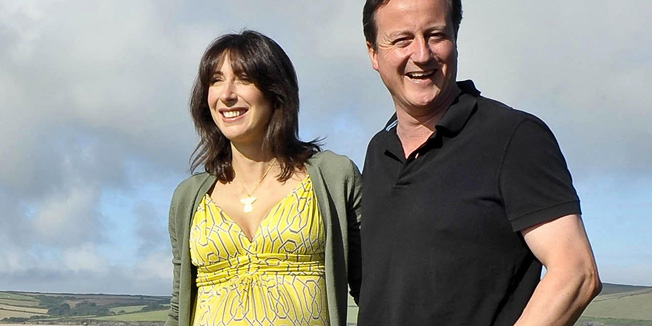 British Prime Minister David Cameron accompanied by his wife Samantha pose on August 22, 2010 on the coastal path at Daymer Bay beach in Cornwall where the family are on holiday. AFP PHOTO / POOL / Ben Birchall  ALTERNATIVE CROP