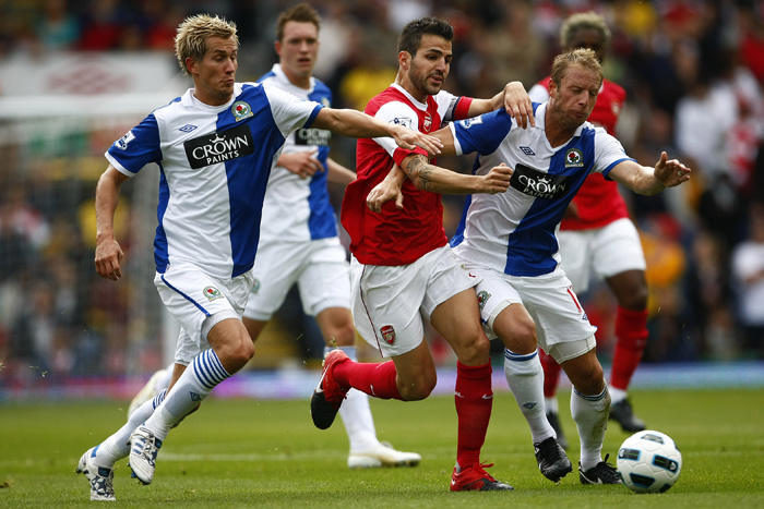 Arsenal's Cesc Fabregas, center, vies for the ball against Blackburn's Morten Gamst Pedersen, left, and Vince Grella, right, during their English Premier League soccer match at Ewood Park, Blackburn, England, Saturday Aug. 28, 2010. (AP Photo/Tim Hales) ** NO INTERNET/MOBILE USAGE WITHOUT FOOTBALL ASSOCIATION PREMIER LEAGUE (FAPL) LICENCE. CALL +44 (0) 20 7864 9121 or EMAIL info@football-dataco.com FOR DETAILS **