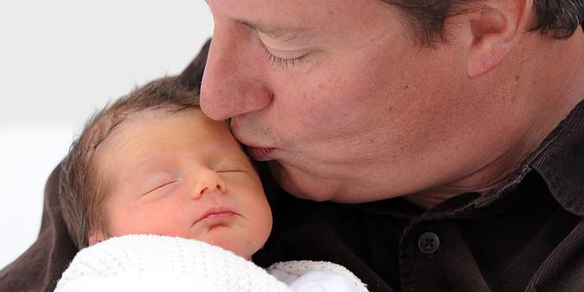 British Prime Minister David Cameron holds on August 28, 2010 his baby daughter, Florence Rose Endellion Cameron, who was born on August 24 during the premier's summer holiday in Cornwall. Cameron's wife Samantha left the Royal Cornwall Hospital in Truro with her new baby on August 27 and returned to their holiday home where the family is continuing their holiday. Cameron will become the first British prime minister to take statutory paternity leave, his deputy confirmed on August 27.   AFP PHOTO / STEFAN ROUSSEAU