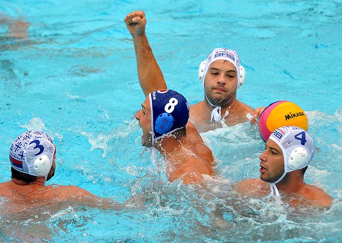 Istvan Marton Szivos of Hungary (C) celebrates his goal in front of Serbia's Filip Filipovic (1R), Vanja Udovicic (R) and Zivko Gocic (L) during their European Waterpolo Championships first round group match in Mladost swimming pool in Zagreb, on August 30, 2010.   AFP PHOTO/ HRVOJE POLAN