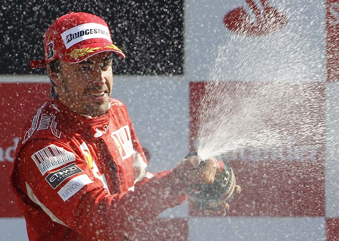 Ferrari driver Fernando Alonso of Spain sprays champagne as he celebrates on podium after winning the Italian Formula One Grand Prix at the Monza racetrack in Monza, Italy, Sunday, Sept. 12, 2010. Fernando Alonso recovered from a poor start to win the Italian Grand Prix for home team Ferrari on Sunday. Alonso lost his pole position to Jenson Button at the first corner but retook the lead after the pit stops to hold on for a 2.9-second victory over his McLaren rival. (AP Photo/Alberto Pellaschiar)
