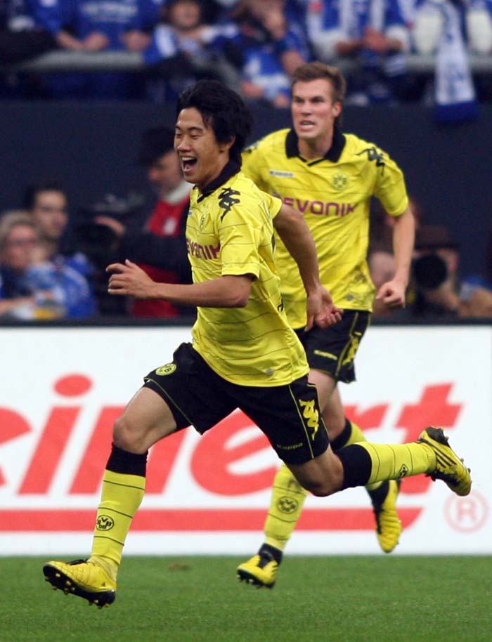 RESTRICTIONS / EMBARGO - ONLINE CLIENTS MAY USE UP TO SIX IMAGES DURING EACH MATCH WITHOUT THE AUTHORISATION OF THE DFL. NO MOBILE USE DURING THE MATCH AND FOR A FURTHER TWO HOURS AFTERWARDS IS PERMITTED WITHOUT THE AUTHORISATION OF THE DFL.Dortmund's Japanese midfielder Shinji Kagawa (L) celebrates after scoring the 0-1 during Germany's first division Bundesliga football match FC Schalke 04 vs Borussia Dortmund on September 19, 2010 at the Veltins Arena stadium in Gelsenkirchen, western Germany.      AFP PHOTO / PATRIK STOLLARZ