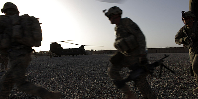 In this Sept. 11, 2010 photo, U.S. infantrymen from the 101st Airborne Division and Afghan Army commandos exit U.S. Army helicopters used to transport troops from one position to another, in Zhari District, southern Afghanistan. Going increasingly on the offensive in this district near Kandahar City, American commanders are hoping to clear Taliban-held areas and fighting positions in the weeks and months ahead, before President Barack Obama makes a critical assessment in December of the effectiveness of the 30,000-man surge. (AP Photo/Brennan Linsley)