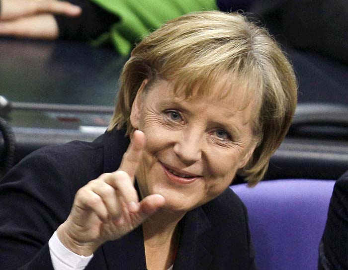 German Chancellor Angela Merkel smiles and points towards the media after her re-election during the meeting of  Germany's lower house of parliament, Bundestag in Berlin, October 28, 2009. Germany's Angela Merkel was formally elected chancellor for a second term on Wednesday by members of parliament, paving the way for her new centre-right coalition to take the reins of power later in the day. REUTERS/Kai Pfaffenbach (GERMANY POLITICS HEADSHOT)