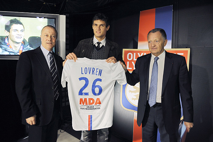 Olympique Lyonnais' football club new player Croatian Dejan Lovren (C) poses with his new jersey, next to Lyon's president Jean Michel Aulas (R) and former football player Bernard Lacombe (L), during his official presentation in Lyon on January 14, 2010. AFP PHOTO / PHILIPPE DESMAZES