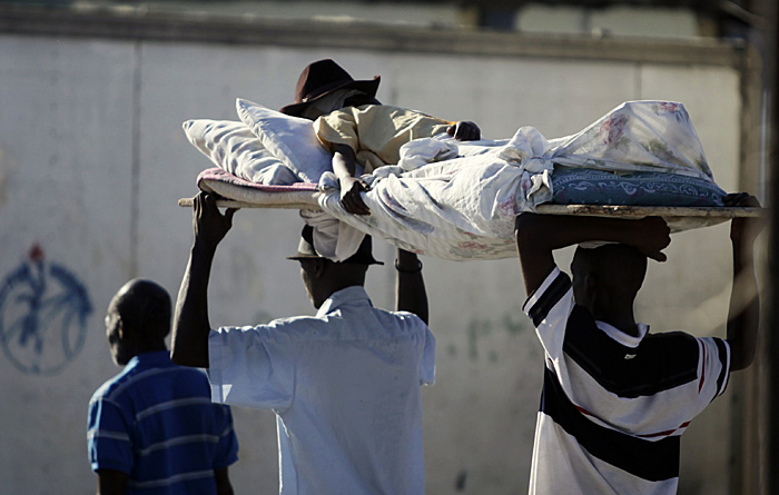 Survivors carry an injured man in Carrefour, in the outskirts of Port-au-Prince, Friday, Jan. 15, 2010. A powerful earthquake hit Haiti on Tuesday. (AP Photo/Ariana Cubillos)