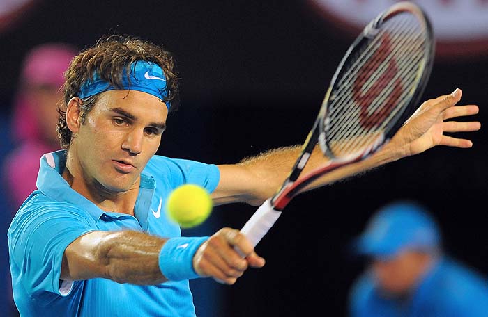 Roger Federer of Switzerland hits a return against Lleyton Hewitt of Australia in their men's singles fourth round match on day eight of the Australian Open tennis tournament in Melbourne on January 25, 2010.  Federer won 6-2, 6-3, 6-4.      AFP PHOTO / WILLIAM WEST