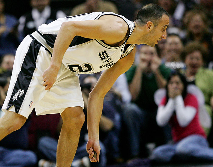 San Antonio Spurs guard Manu Ginobili picks up a bat to remove it from the court after swatting the animal from the air as it flew around the AT&T Center during the first half of an NBA basketball game against the Sacramento Kings, Saturday, Oct. 31, 2009, in San Antonio. (AP Photo/Darren Abate)