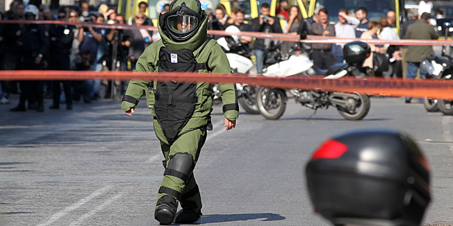 A police explosive expert prepares a controlled blast in Athens, Monday, Nov. 1, 2010. A woman was wounded after a package exploded at a private delivery company, while two other suspected mail bombs were destroyed by police in controlled blasts in the capital, police officials said. The two men suspected of taking part in the attacks were arrested, carrying handguns, wigs, and one of them was also wearing a bulletproof vest, police said.  (AP Photo/Thanassis Stavrakis)