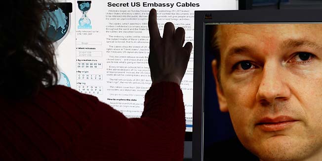 This illustration taken on November 30, 2010 in Schwerin, northeastern Germany, shows a woman watching the internet site of WikiLeaks as on the screen at (R) can be seen a photo of WikiLeaks-founder Julian Assange. WikiLeaks faced a worldwide backlash over its release of secret US diplomatic cables, with some countries saying the revelations undermined diplomacy while others dismissed them as worthless.     AFP PHOTO    JENS BUETTNER    GERMANY OUT