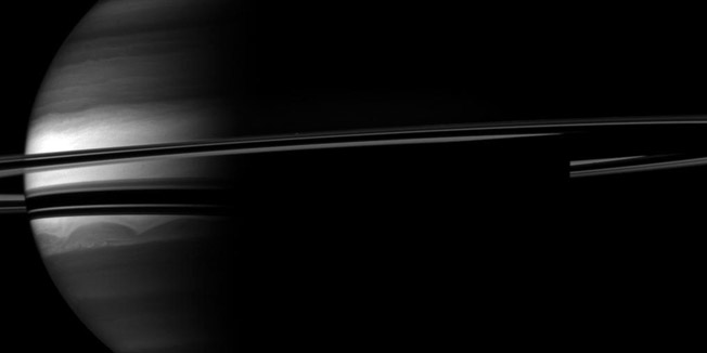 A crescent Saturn appears nestled within encircling rings in this Cassini spacecraft image provided by NASA on November 23, 2010. Clouds swirl through the atmosphere of the planet and a barely visible Prometheus orbits between the planet's main rings and its the thin F ring. Saturn's moon Prometheus appears as a speck above the rings near the middle of the image. This view looks toward the southern, unilluminated side of the rings from about 3 degrees below the ringplane.The image was taken with the Cassini spacecraft's wide-angle camera on Sept. 14, 2010, and was obtained at a distance of approximately 1.6 million miles, or 2.6 million kilometers, from Saturn and at a sun-Saturn-spacecraft, or phase, angle of 100 degrees. AFP PHOTO/NASA/JPL/SPACE SCIENCE INSTITUTE/HANDOUT/RESTRICTED TO EDITORIAL USE