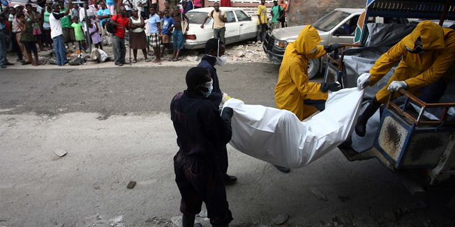 Health personnel remove a disinfected body of a person whose death was possibly caused by cholera, November 22, 2010 in Port-au-Prince. Haitian health officials said at least 1,344 people have died from a worsening cholera epidemic that has ravaged the country since mid-October.  The capital city Port-au-Prince, seen as being particularly at risk of widespread infection because of the crowded and unsanitary conditions endured by tens of thousands of people sheltering in squalid, makeshift tent cities, has seen a total of 77 cholera deaths, officials said.   AFP PHOTO/Hector Retamal