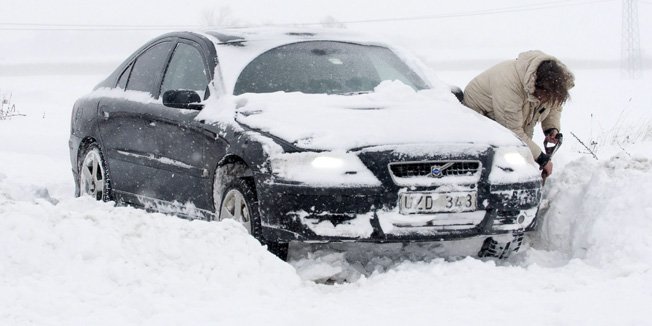 A driver digs her car out of snow on the road between Trelleborg and Malmo after heavy snowfall on December 2, 2010. Fresh snowfalls swept northern Europe once again, causing misery for travellers as airports remain closed, roads were blocked and Eurostar international rail services were cancelled.   AFP PHOTO / SCANPIX-SWEDEN / JOHAN NILSSON   ***SWEDEN OUT***