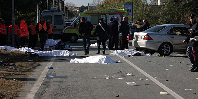 Sheets cover the bodies of cyclists after a speeding car, seen at right, plowed head-on into their group in southern Italy on Sunday morning, killing eight of them, in Lamezia Terme, Italy, Sunday, Dec. 5, 2010. The driver had been smoking marijuana, police said. Bent, mangled bikes were strewn about the scene, and the sheet-draped corpses dotted the two-lane road near Lamezia Terme, in the Calabrian 
