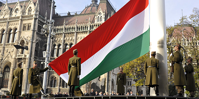 Hungarian guard of honor places the national flag on half-mast as a mark of respect for the victims of the 1956 anti-communist revolution in front of the Parliament building in Budapest, Hungary, Thursday, Nov. 4, 2010. Hungary commemorates Nov 4 as the day when in 1956 Soviet troops smashed the 1956 revolution in Hungary. (AP Photo/Bela Szandelszky)