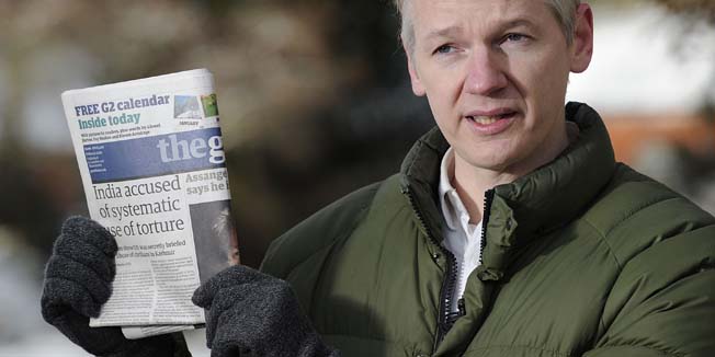 WikiLeaks founder Julian Assange holds up a copy of Britain's Guardian newspaper as he addreses media in the grounds of Ellingham Hall in Norfolk, eastern England, on December 17, 2010. Assange said on Thursday he had heard rumours that he had been indicted in the United States, shortly after he was freed on bail in Britain. AFP PHOTO/CARL COURT