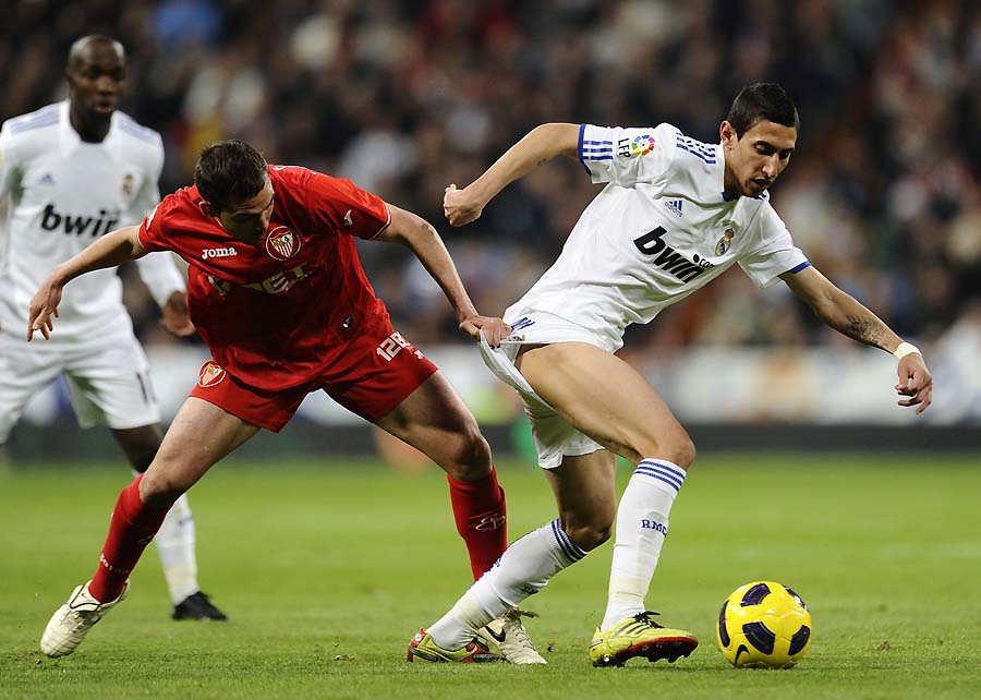 Real Madrid's Argentinian midfielder Angel di Maria (R) vies with Sevilla's defender Fernando Navarro during the Spanish league football match Real Madrid CF vs Sevilla FC on December 19, 2010 at the Santiago Bernabeu stadium in Madrid.    AFP PHOTO/ PIERRE-PHILIPPE MARCOU