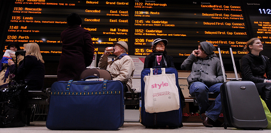 Passengers sit underneath an electronic information board showing cancelled and delayed trains, at Kings Cross train station in London, on December 21, 2010.  Thousands of angry travellers forced to sleep in airports and train stations across Europe faced more misery Tuesday as fresh snowfalls paralysed transport systems just days before Christmas.    London Heathrow, Europe's busiest airport, was only operating about a third of its normal schedule during a fourth day of disruption, while Frankfurt halted all flights after a new blanketing of snow.             AFP PHOTO/BEN STANSALL