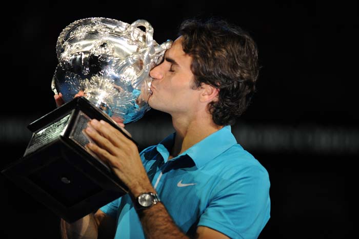 Swiss tennis player Roger Federer kisses the trophy after victory in his men's singles final match against British opponent Andy Murray at the Australian Open tennis tournament in Melbourne on January 31, 2010.   Federer won 6-3. 6-4. 7-6.    AFP PHOTO/Greg WOOD