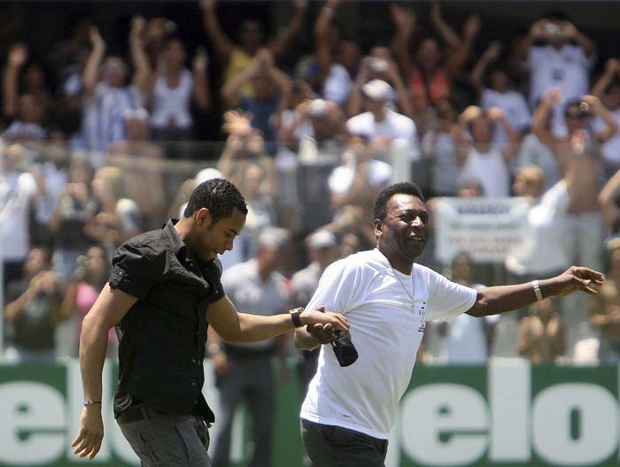Brazilian striker Robinho (L) is pulled by soccer legend Pele during his presentation in Santos February 1, 2010. Robinho arrived in Brazil on Saturday to begin a six-month loan spell with Santos from English Premier League side Manchester City. The 26-year-old asked City for the loan move in a bid to improve his chances of making Brazil's 2010 World Cup squad after struggling in England. REUTERS/Alex Almeida (Brazil - Tags: SPORT SOCCER)