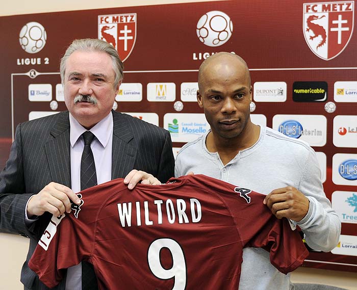 French Sylvain Wiltord  poses with his new jersey next to Metz's football club president Bernard Serin (L) on February 01, 2010 in Metz, after signing a one-year contract with the French second league club.AFP PHOTO / JEAN-CHRISTOPHE VERHAEGEN