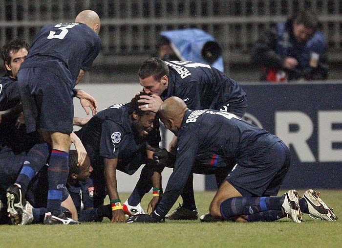 Olympique Lyon's Jean Makoun (C) celebrates with team mates after scoring against Real Madrid during their Champions League soccer match at the Gerland stadium in Lyon, February 16, 2010. REUTERS/Jean-Paul Pelissier  (FRANCE - Tags: SPORT SOCCER IMAGES OF THE DAY)