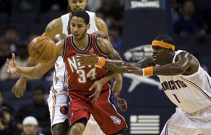 New Jersey Nets guard Devin Harris (34) loses control of the ball against Charlotte Bobcats guard Stephen Jackson (1) during an NBA basketball game in Charlotte, North Carolina February 16, 2010. REUTERS/Chris Keane (UNITED STATES - Tags: SPORT BASKETBALL)